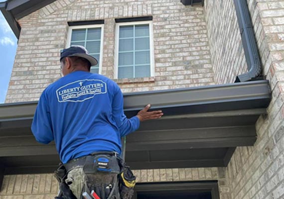 worker-installing-gutters on a home